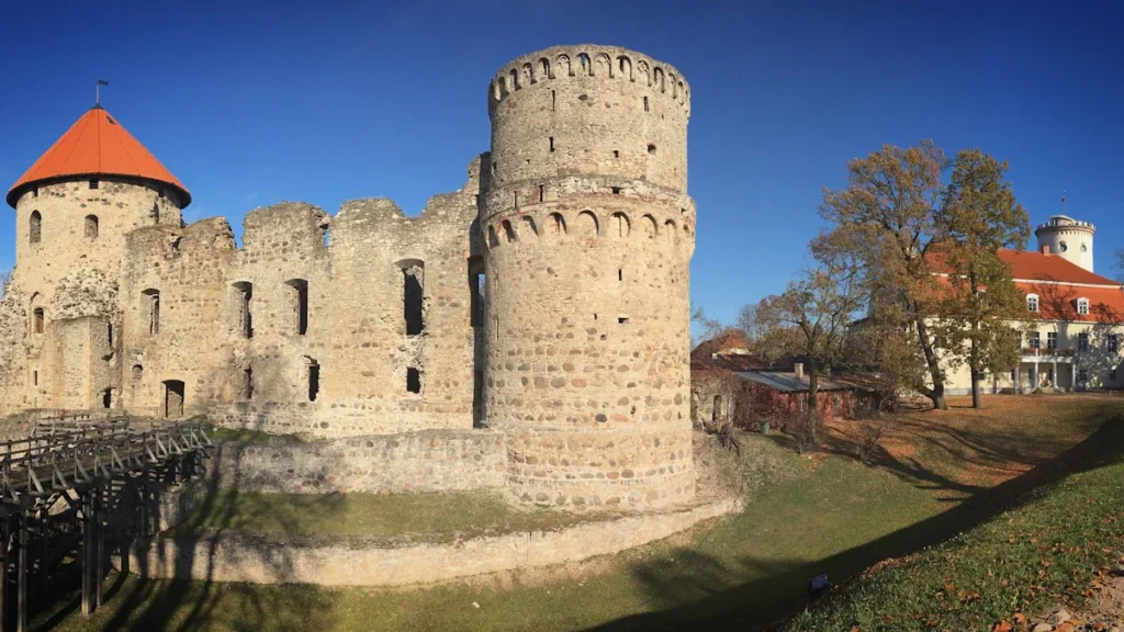 Vue panoramique du château médiéval de Cēsis sous un ciel bleu.
