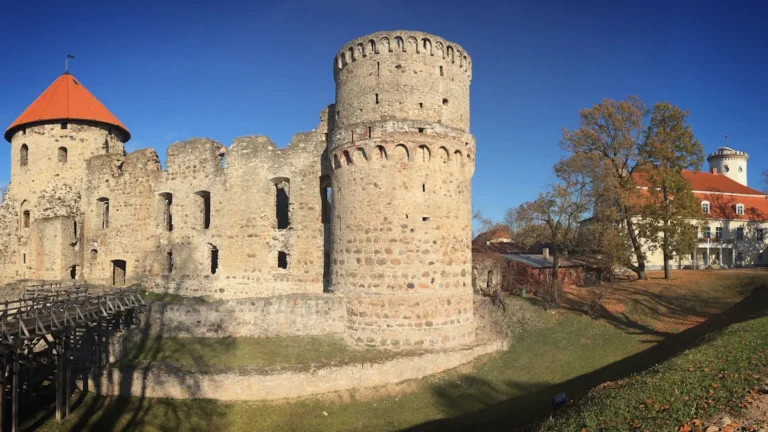 Vue panoramique du château médiéval de Cēsis sous un ciel bleu.