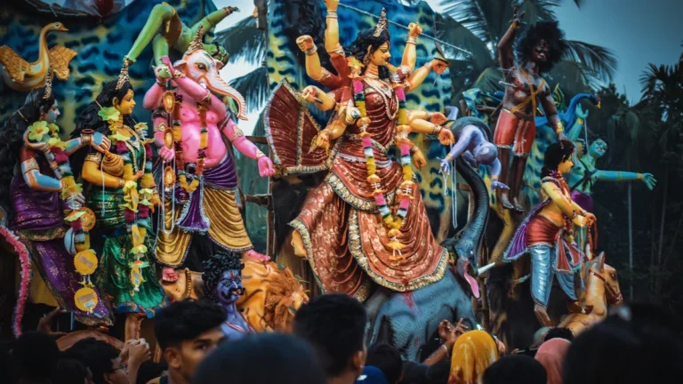Krāšņas hinduistu dievību statujas procesijā Bangladešā, kas vizuāli neatbilst raksta saturam par Latviju.
