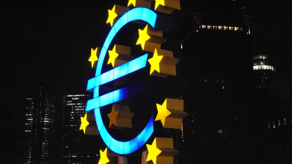 Izgaismots eiro simbols naktī, kas simbolizē Eiropas Centrālās bankas pieņemtos finanšu lēmumus.
