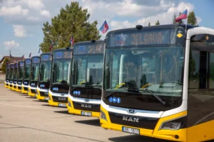 Rindā novietoti vairāki jauni dzelteni un balti MAN autobusi ar galamērķa norādi Jelgava.