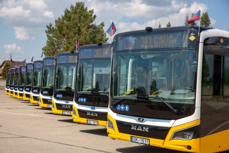 Rindā novietoti vairāki jauni dzelteni un balti MAN autobusi ar galamērķa norādi Jelgava.