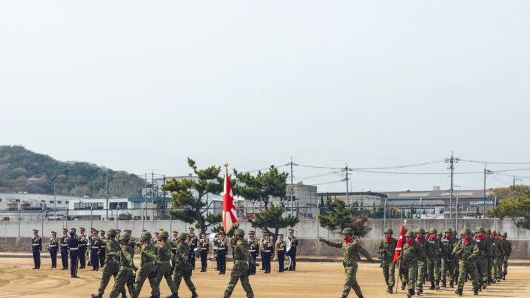Karavīru ierinda maršē ar karogiem parādes laukumā svinīgā militārā pasākuma laikā.