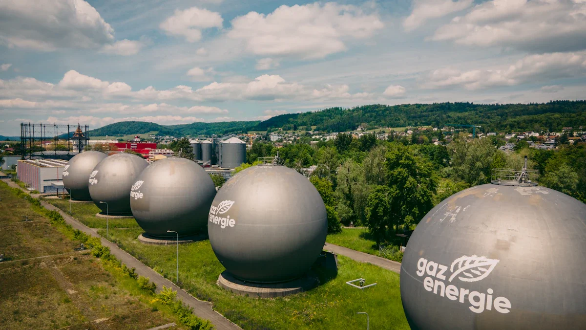 Sfēriskas dabasgāzes tvertnes ar lapas simbolu uz zaļa lauka pilsētas industriālajā zonā.