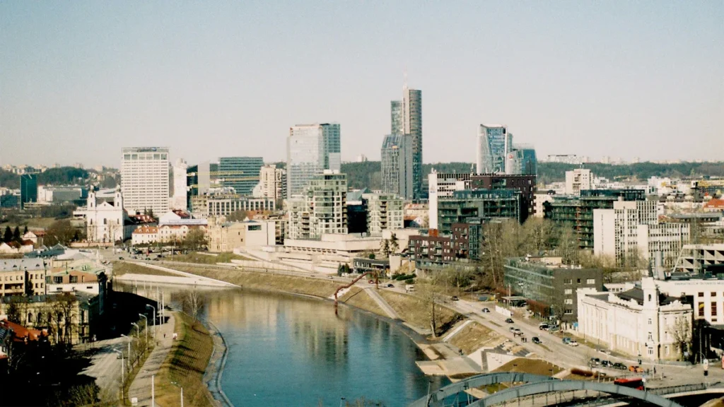 Viļņas panorāma ar modernām biroju ēkām un Neres upi saulainā dienas laikā.