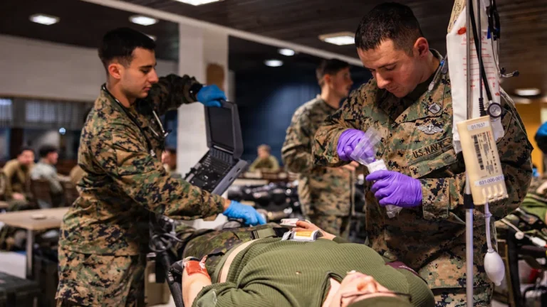 Militārie mediķi sniedz medicīnisko palīdzību cietušajam lauka hospitālī mācību laikā.