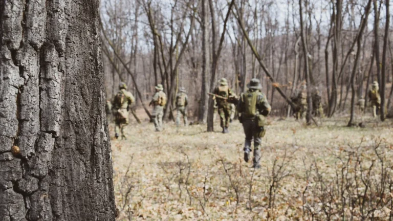 Karavīri kamuflāžas tērpos pārvietojas pa mežu militāro mācību laikā pierobežas zonā.