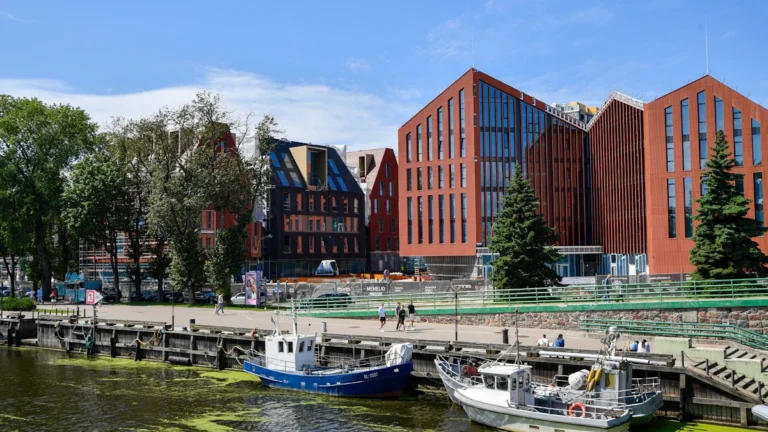 Mūsdienīga arhitektūra Klaipēdā pie Danes upes, demonstrējot pilsētas ekonomiskās attīstības un investīciju vērienu.