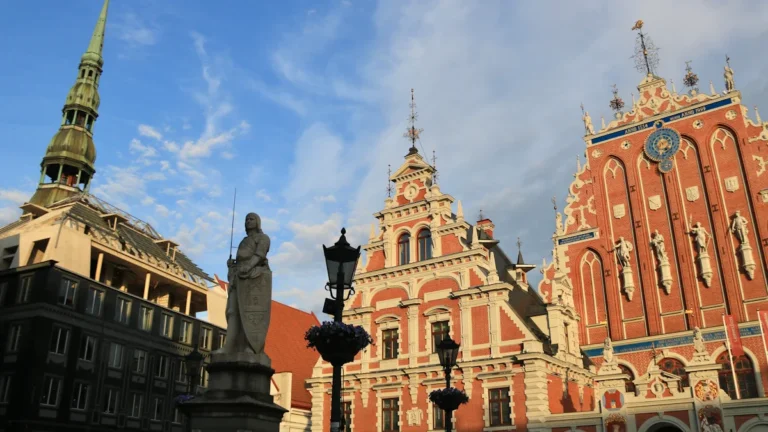 Vēsturiskais Melngalvju nams un Svētā Pētera baznīcas tornis Vecrīgā zem skaidrām debesīm.