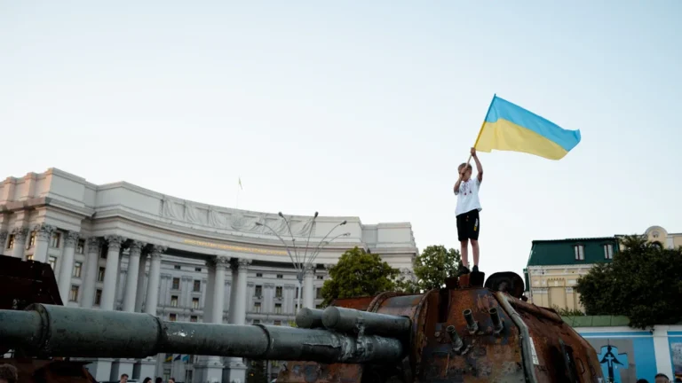 Zēns ar Ukrainas karogu stāv uz iznīcināta krievu tanka Kijivā