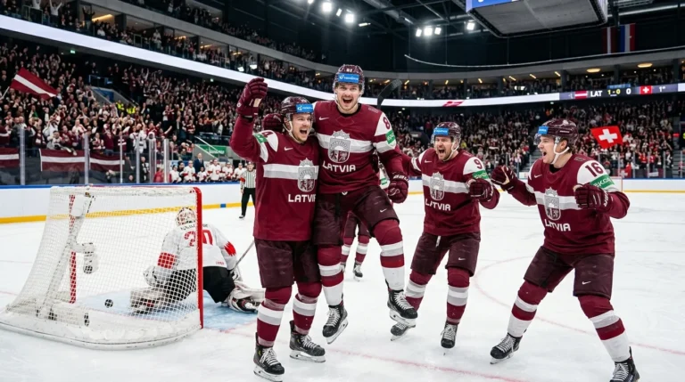 Četri Latvijas hokejisti bordo formās priecājas par gūtajiem vārtiem pārpildītā hokeja hallē uz ledus.