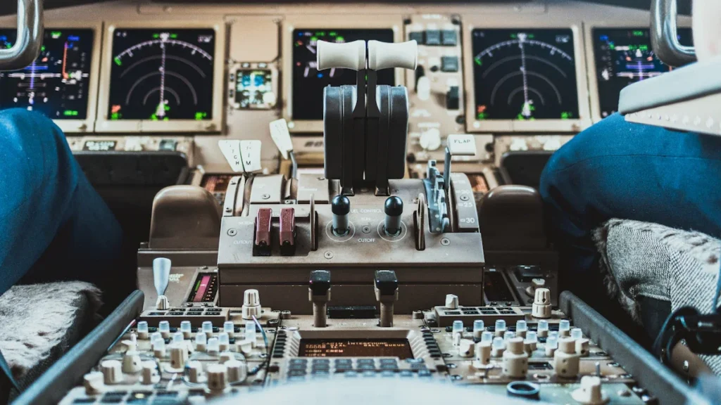 Lidmašīnas piloti sēž pie vadības pults modernā aviolīniju kabīnē lidojuma laikā.
