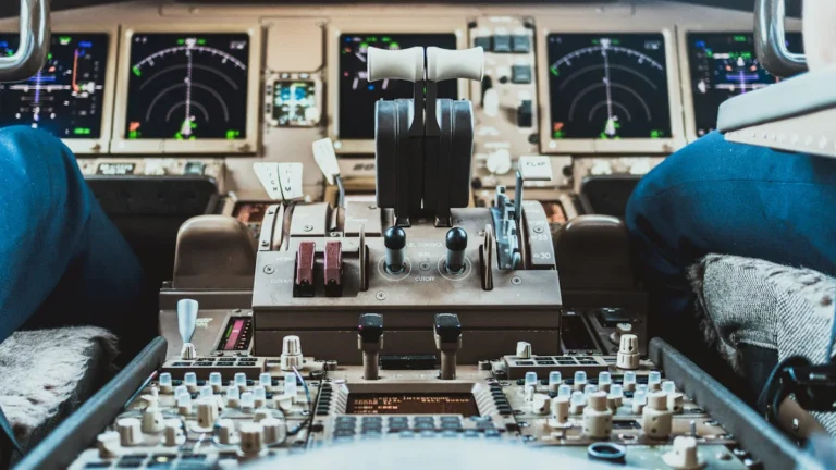 Lidmašīnas piloti sēž pie vadības pults modernā aviolīniju kabīnē lidojuma laikā.