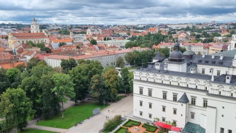 Skats uz Viļņu no putna lidojuma ar sarkanu gaisa balonu virs pilsētas vecpilsētas un katedrāles.
