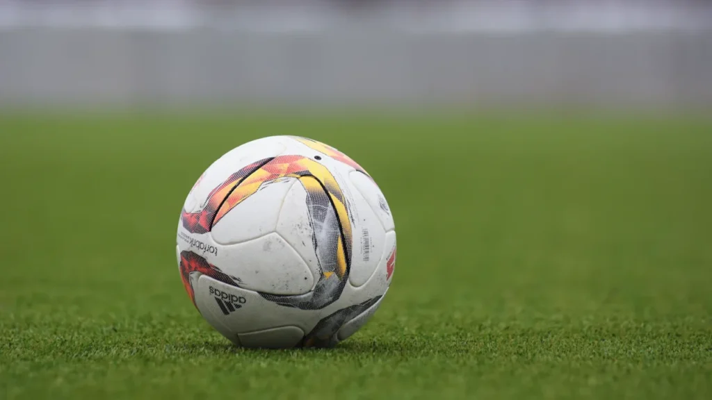 Klasiska futbola bumba uz zaļa zālāja pirms izšķirošās FIFA Pasaules kausa finālspēles sākuma