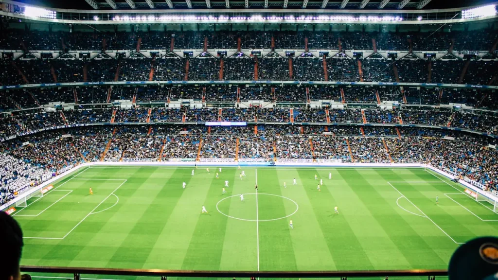 Futbola stadions ar skatītājiem tribīnēs pirms svarīgas starptautiskas futbola spēles sākuma.