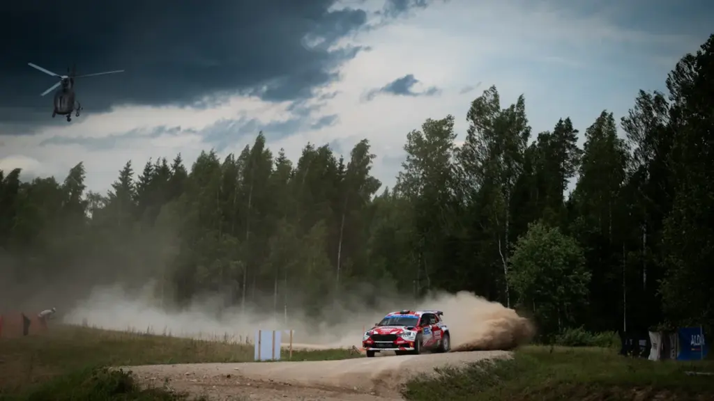 Sporta rallija sacīkšu auto brauc pa putekļainu meža ceļu Gulbenes novada pasākumā.
