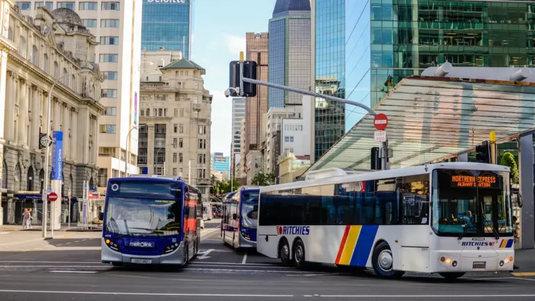 Pilsētas autobuss brauc pa ielu gaišā dienas laikā pilsētas centrā.