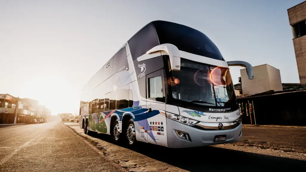 Pelēks un melns reģionālais autobuss novietots stāvvietā dienas laikā.