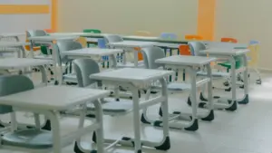 Kārtīgi izvietoti skolas soli un krēsli tukšā mācību klasē pirms stundām.