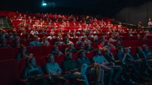 Skatītāji sēž kinoteātra zālē un gaida filmas «Uļa» pirmizrādes sākumu Cēsīs.