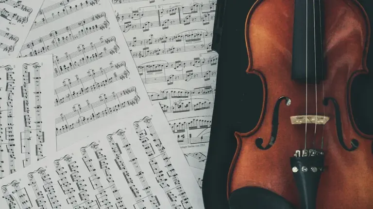 Klasiska čella instrumenta attēls uz nošu lapu fona pirms koncerta sākuma.