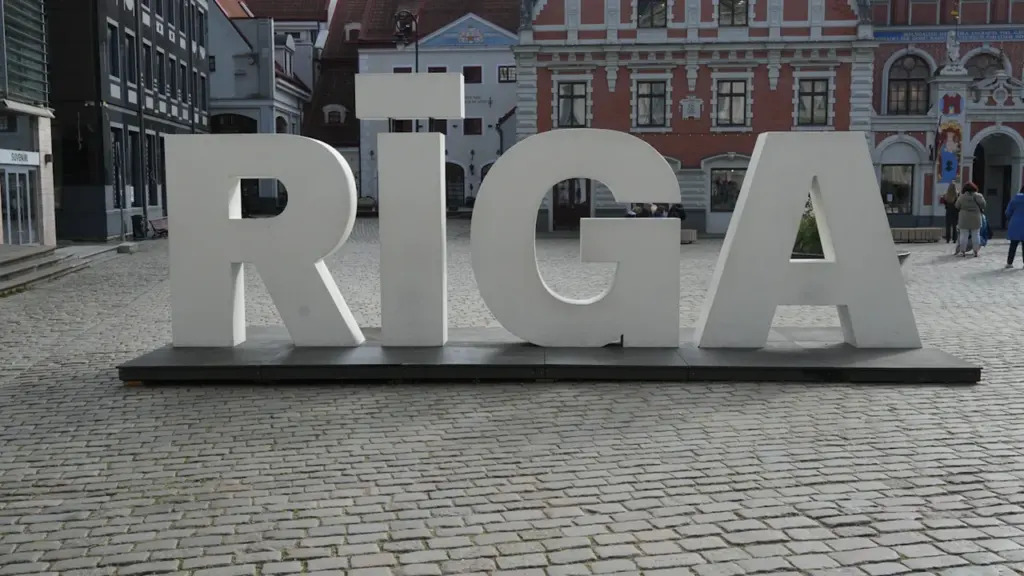 Liels uzraksts RĪGA uz bruģēta laukuma Rīgas vēsturiskajā centrā.